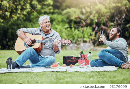Guitar, father and son on park picnic with beer and music during holiday in Australia in summer. Senior dad and man laughing at comic sound on instrument while happy on vacation in a nature garden Guitar, father and son on park picnic with beer and music during holiday in Australia in summer. Senior dad and man laughing at comic sound on instrument while happy on vacation in a nature garden 98176099
