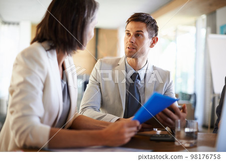 They have a lot on their plate today. Two businesspeople having an important discussion at a meeting. 98176758