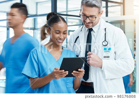 Diversity, doctor and nurse on a tablet planning a surgery strategy or talking about medical results in a hospital. Teamwork, collaboration and happy healthcare workers speaking and reading a report 98176808