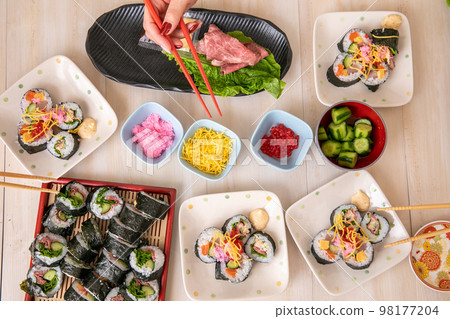 Hands of a woman who enjoys hand-rolled sushi 98177204