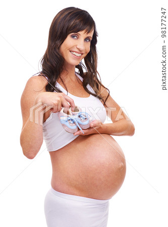 Getting prepared for the new arrival. A pregnant mother holding a pair of baby shoes in front of her belly. Getting prepared for the new arrival. A pregnant mother holding a pair of baby shoes in front of her belly. 98177247