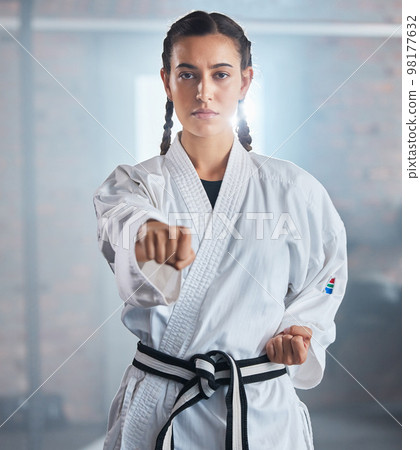 Woman, karate and punching pose in taekwondo fitness, workout or training for black belt competition, fight challenge or self defense. Portrait, martial arts and judo sports person in power exercise 98177632