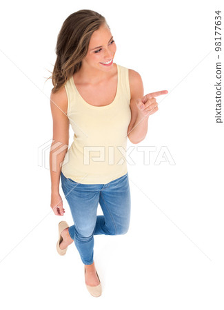 Theres something for you over there. High angle shot of a beautiful young woman standing against a white background. 98177634
