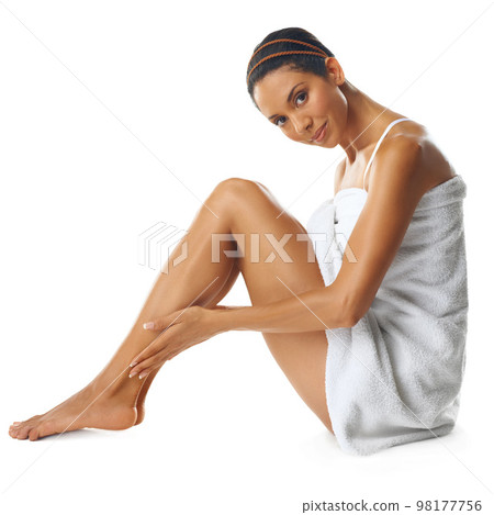 Legs, skincare and portrait with a model black woman in studio on a white background in a towel for natural beauty. Spa, wellness and luxury treatment with an attractive young female sitting in a spa 98177756