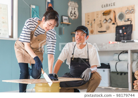 在房屋倉庫用鋸鋸木頭的亞洲男女（DIY教室、工作坊、DIY、體驗課） 98179744