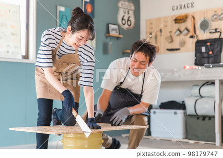 Asian men and women who cut wood with a saw in a house warehouse (DIY classroom, workshop, DIY, experience class) Asian men and women who cut wood with a saw in a house warehouse (DIY classroom, workshop, DIY, experience class) 98179747