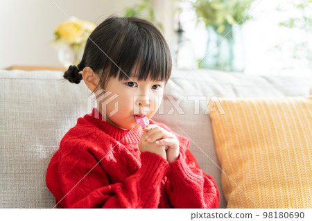 Child licking candy with a stick (candy / sweets) 98180690