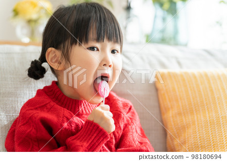 孩子用棍子舔糖果（糖果/糖果） 98180694