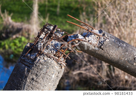 Broken concrete pillar with rusty reinforcement Broken concrete pillar with rusty reinforcement 98181433