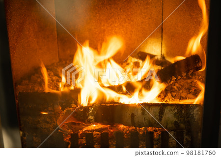 Firewood is burning in the furnace of the hearth close-up. Alternative eco-friendly heating, warm cozy room at home, burning wood Firewood is burning in the furnace of the hearth close-up. Alternative eco-friendly heating, warm cozy room at home, burning wood 98181760
