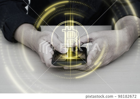 Bitcoin symbol hologram on mobile screen. Cryptocurrency and future technology concept. Bitcoin symbol hologram on mobile screen. Cryptocurrency and future technology concept. 98182672