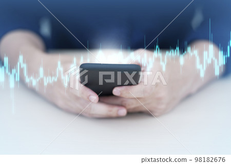 Trader using mobile phone app analytics for cryptocurrency graph. Trader using mobile phone app analytics for cryptocurrency graph. 98182676