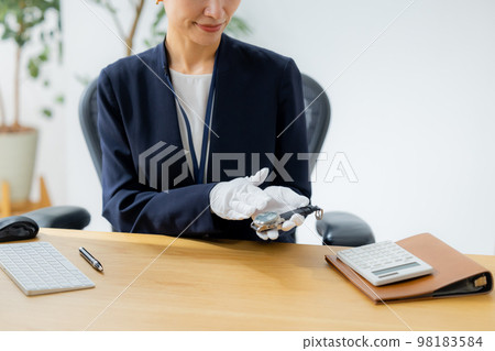 A woman appraising a watch A woman appraising a watch 98183584