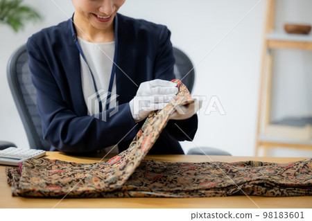 A woman appraising a kimono A woman appraising a kimono 98183601