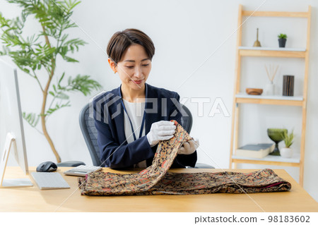 A woman appraising a kimono A woman appraising a kimono 98183602