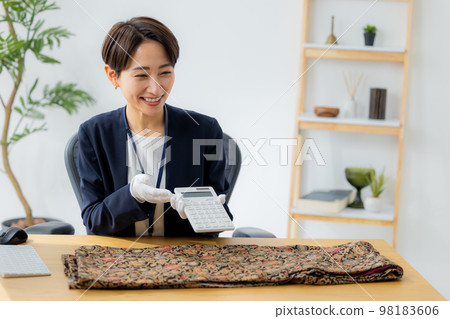 A woman appraising a kimono A woman appraising a kimono 98183606