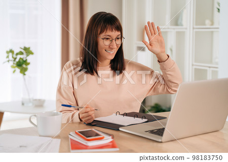 Young woman has video call while working remotely from home 98183750