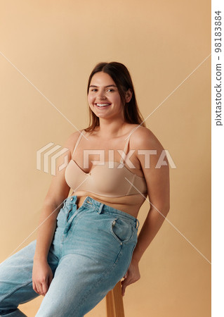 Full Figured Woman. Happy Curvy Oversize Woman In Beige Lingerie Sitting Chair 98183884