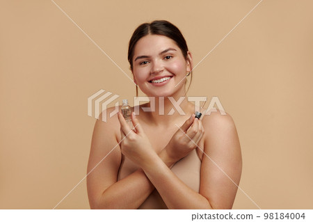 Woman Applying Serum on Face. Woman Applying Essential Oil On Facial Skin 98184004