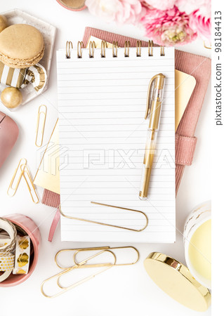 Feminine desktop with gold and pink stationery including a keyboard and mouse 98184413