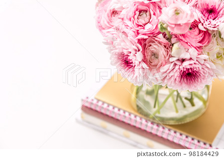 Feminine desktop with gold and pink stationery including fresh flowers 98184429