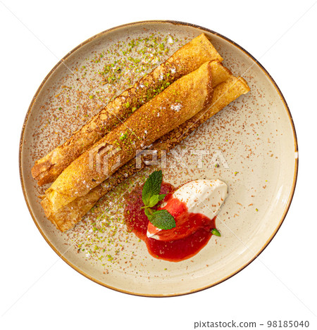 Isolated sweet crepe roll with cream and jam Isolated sweet crepe roll with cream and jam 98185040