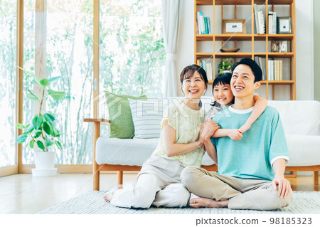 A young family relaxing in the living room A young family relaxing in the living room 98185323