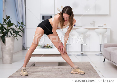 Fit woman exercising at home. Fit woman exercising at home. 98185528