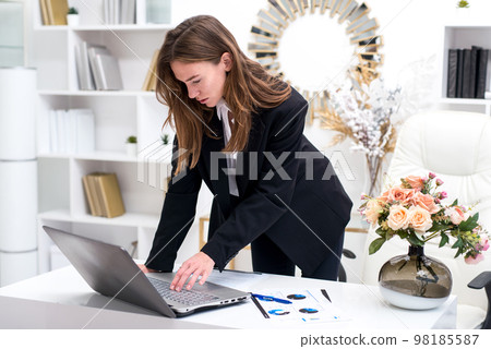 Woman leaves her workplace and finally turns off her laptop 98185587