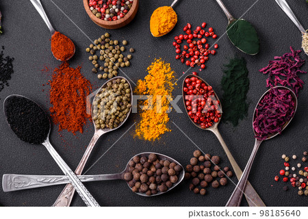 Several types of spices in metal spoons paprika, tomatoes, curry, beets, cumin, turmeric, fennel, spirulina 98185640
