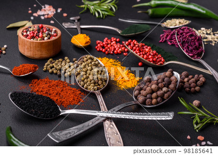 Several types of spices in metal spoons paprika, tomatoes, curry, beets, cumin, turmeric, fennel, spirulina 98185641