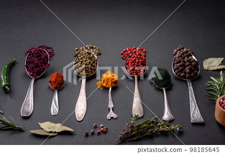 Several types of spices in metal spoons paprika, tomatoes, curry, beets, cumin, turmeric, fennel, spirulina 98185645
