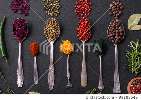 Several types of spices in metal spoons paprika, tomatoes, curry, beets, cumin, turmeric, fennel, spirulina 98185649