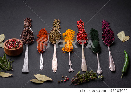Several types of spices in metal spoons paprika, tomatoes, curry, beets, cumin, turmeric, fennel, spirulina 98185651