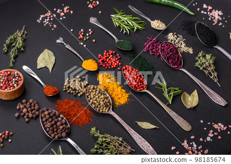 Several types of spices in metal spoons paprika, tomatoes, curry, beets, cumin, turmeric, fennel, spirulina 98185674