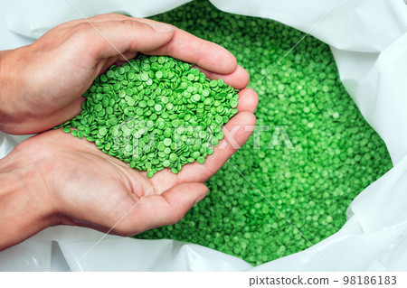 hands hold or touching biodegradable plastic pellets, plastic polymer granules 98186183