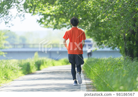 Man running outdoors full body back view 98186567