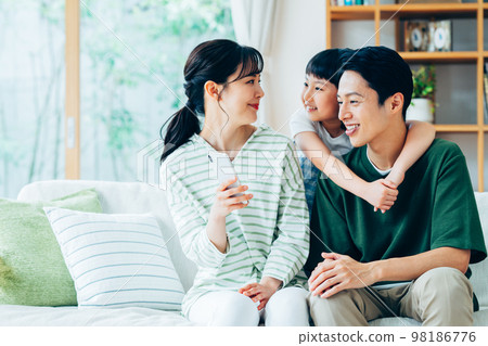 A young family relaxing in the living room　 98186776
