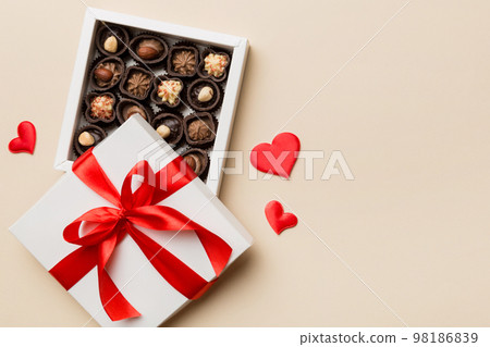 Delicious chocolate pralines in red box for Valentine's Day. Heart shaped box of chocolates top view with copy space 98186839