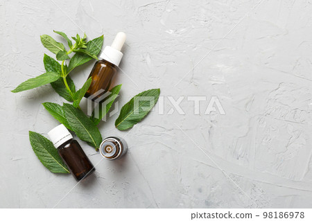 Natural Mint Essential Oil in a Glass Bottle. organic cosmetics with herbal extracts of mint on colored background 98186978