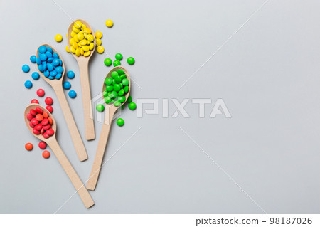 delicious colorful sweet candies on spoon on colored background . Confectionery decor top view with copy space 98187026