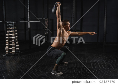 Kettlebells swing exercise man workout at gym. Crossfit training Kettlebells swing exercise man workout at gym. Crossfit training 98187170