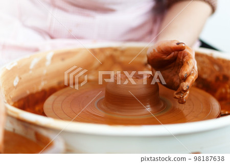 Potter creates a pitcher on a pottery wheel 98187638