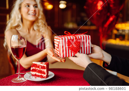 Valentine's Day concept. Exchange of gifts. Beautiful young couple celebrating Valentine's Day . 98188601