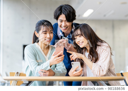 Male and female college students looking at smartphones 98188636