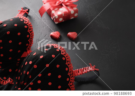 Valentine's day gift, chocolate sweets and bustier underwear for Romantic dating on black background. Close up. 98188693