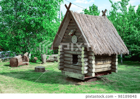 A wooden hut on a green lawn among the trees on the territory of 98189848