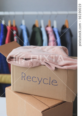 recycling, old clothes in cardboard box. textiles, paper at home and hand over recycling, old clothes in cardboard box. textiles, paper at home and hand over 98190019