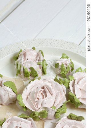 Homemade zephyr roses dry on a tray. On a white background. Close-up. 98190406
