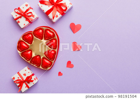 Delicious chocolate pralines in box for Valentine's Day. Heart shaped with gift box of chocolates top view with copy space Delicious chocolate pralines in box for Valentine's Day. Heart shaped with gift box of chocolates top view with copy space 98191504